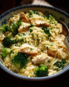 Creamy cheesy chicken and broccoli orzo served in a bowl