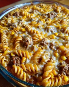 Cheesy ranch rotini bake topped with beef and sweet corn in a casserole dish