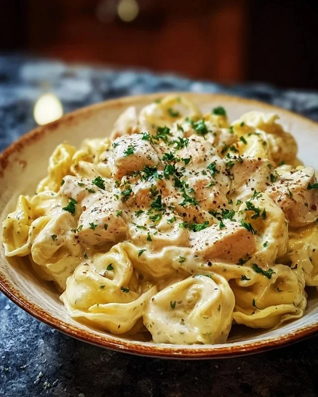 Crockpot Chicken Alfredo Tortellini in a creamy sauce, served in a bowl.