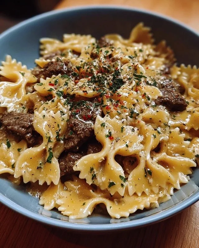 Creamy Parmesan Garlic Beef Bowtie Pasta served in a bowl with herbs
