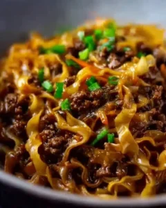 Plate of easy Mongolian ground beef noodles garnished with green onions