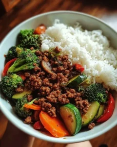 Spicy ground beef stir-fry bowl with garlic veggies and rice