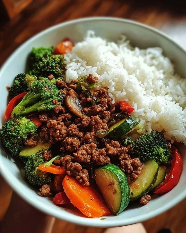 Spicy ground beef stir-fry bowl with garlic veggies and rice
