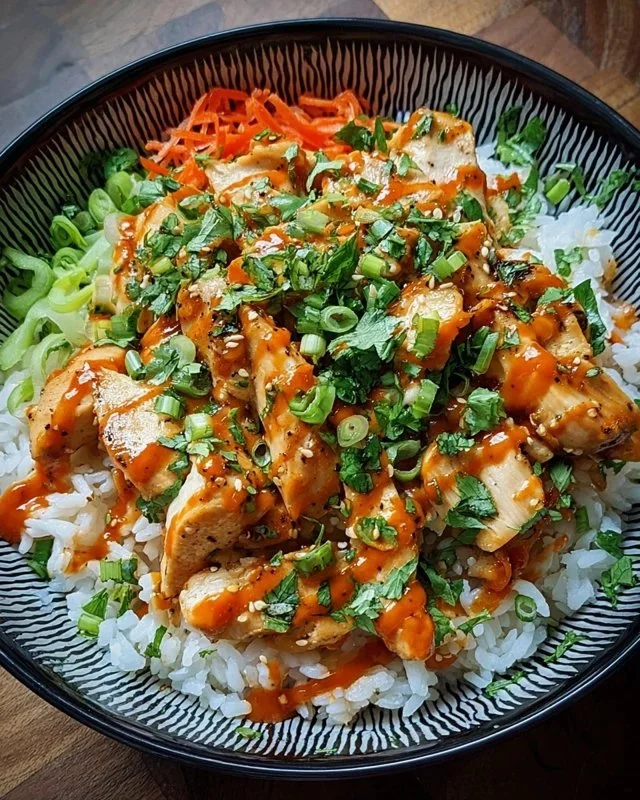 Bang Bang Chicken Bowl garnished with fresh herbs and veggies