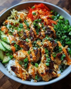 Bang Bang Chicken Bowl topped with colorful vegetables and spicy sauce