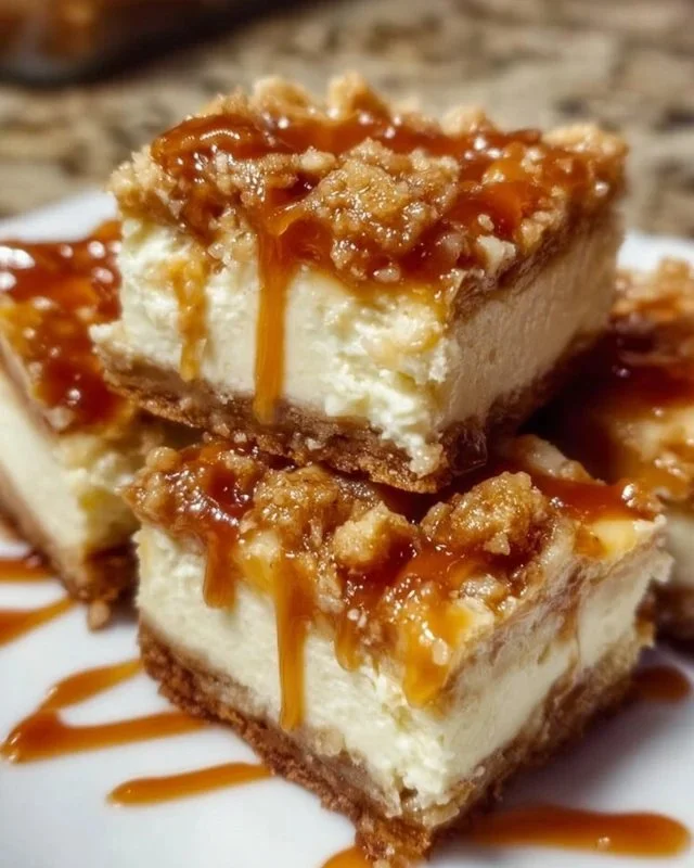 Delicious Caramel Apple Cheesecake Bars topped with caramel sauce and apple slices.