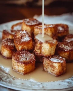 Cinnamon Roll French Toast Bites served with syrup and powdered sugar