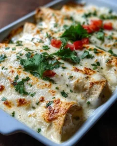 Delicious creamy white chicken enchiladas topped with sauce and cheese