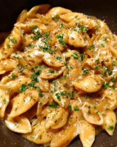 Bowl of easy French onion pasta topped with cheese and caramelized onions