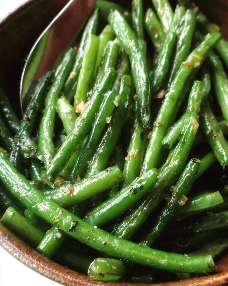 Plate of garlic butter sautéed green beans with garlic and herbs