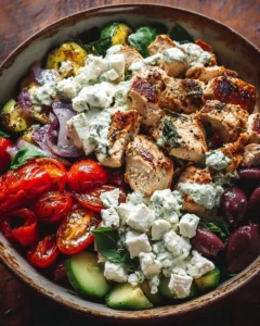 A vibrant Greek Chicken Bowl featuring grilled chicken, fresh vegetables, and tzatziki sauce.