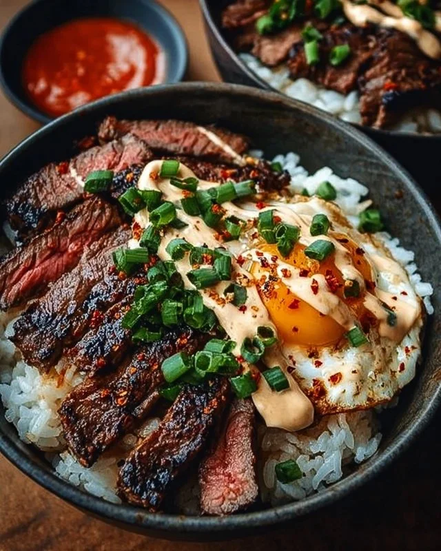 Delicious Korean BBQ steak rice bowl with vibrant vegetables and sauce.