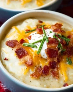 Bowl of loaded baked potato soup garnished with cheese, bacon, and green onions.