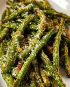Parmesan roasted green beans topped with cheese in a serving dish