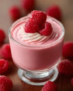 Delicious homemade raspberry mousse dessert topped with fresh raspberries.