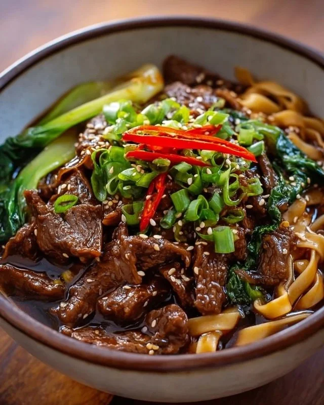 Delicious sticky beef noodles topped with herbs and vegetables