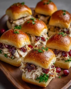 Thanksgiving turkey sliders with cranberry sauce on a platter.