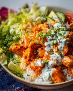 Delicious Buffalo Chicken Bowls garnished with fresh vegetables and sauces