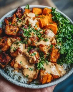 Chicken and sweet potato bowls topped with fresh vegetables and herbs.