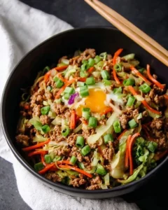 High protein egg roll in a bowl with colorful vegetables and savory sauce.