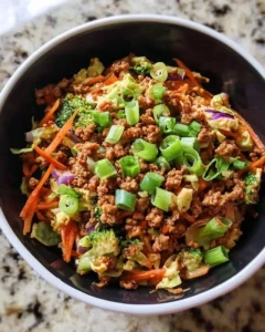 High protein egg roll in a bowl topped with fresh vegetables and savory sauce.