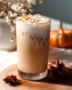 Iced Pumpkin Cream Chai Tea Latte with seasonal spices and pumpkin garnish