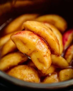 Instant Pot cinnamon apples in a bowl, garnished with cinnamon sticks and served warm.
