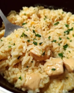 Bowl of Instant Pot creamy chicken and rice with herbs and vegetables.