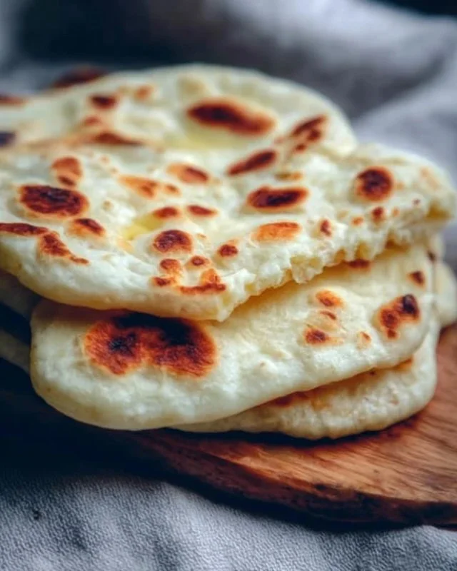 Homemade sourdough discard naan bread on a wooden table.