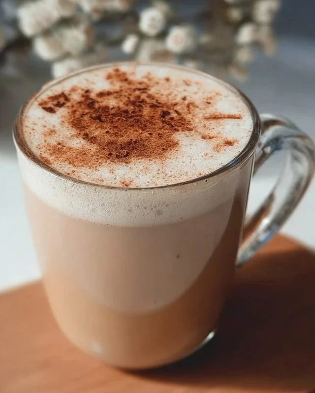 Creamy Vanilla Chai Latte in a cup with spices and vanilla pods