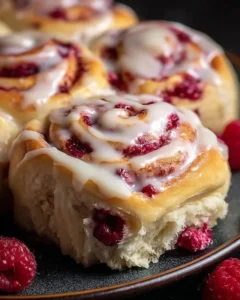 Freshly baked White Chocolate Raspberry Rolls with raspberry filling and white chocolate drizzle