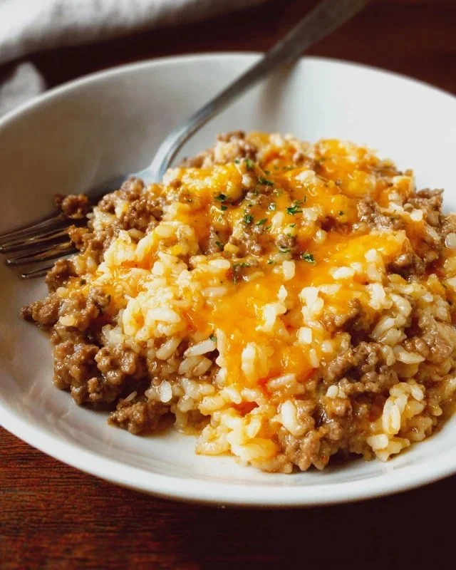 Cheesy ground beef and rice casserole served in a baking dish topped with melted cheese.