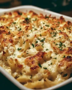 Creamy Chicken Alfredo Pasta Bake in a baking dish garnished with fresh parsley
