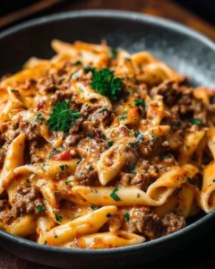 Creamy beef pasta dish garnished with herbs and served in a bowl