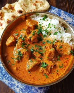Delicious easy butter chicken served with rice and garnished with cilantro.