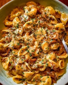 A plate of Easy French Onion Pasta topped with cheese and herbs.