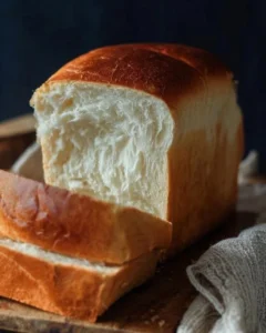 Freshly baked easy milk bread loaf on a wooden cutting board