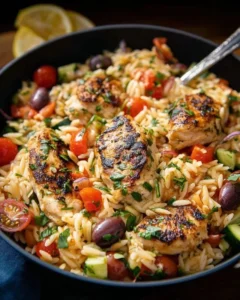 Plate of Mediterranean Chicken Orzo with fresh vegetables and herbs