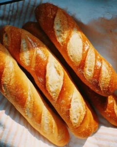 Freshly baked homemade baguettes on a wooden board