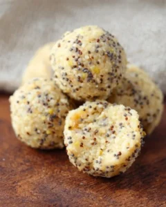 Lemon Poppy Seed Energy Bites on a plate garnished with lemon slices and poppy seeds.