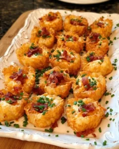 Delicious loaded tater tots appetizers topped with cheese and toppings.