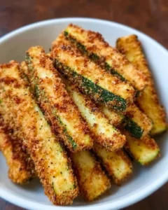 Low calorie air fryer zucchini fries served in a bowl with dipping sauce.