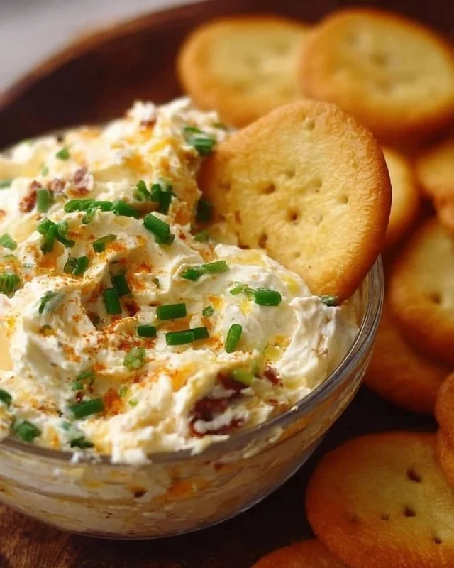 Delicious Million Dollar Dip served in a bowl with fresh vegetables and crackers.