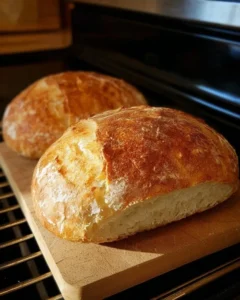 Two loaves of homemade peasant bread cooling on a wire rack.