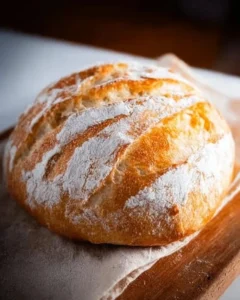 Freshly baked no-knead artisan bread loaf on a wooden table