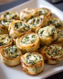 Bite-sized pinwheels filled with spinach dip on a platter