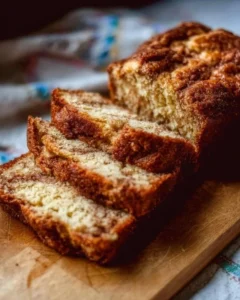 Loaf of freshly baked Amish Cinnamon Bread with cinnamon swirl topping
