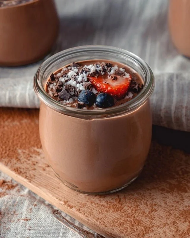 Delicious chocolate protein pudding in a bowl, topped with berries