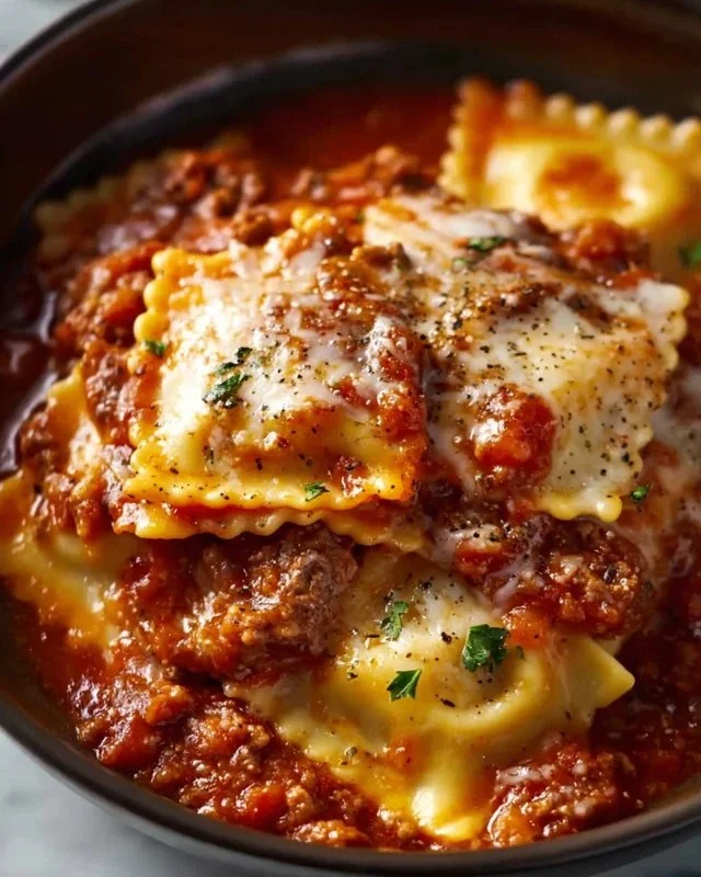 Delicious crockpot ravioli lasagna served in a bowl, showcasing layers of cheese and sauce.