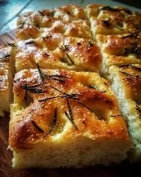 Homemade focaccia bread topped with herbs and olive oil
